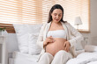 © Pixel-Shot - Young pregnant woman sitting in bedroom