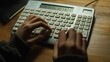 © Heng Kimhong - Close-up of hands using a keyboard and calculator to calculate taxes