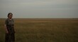 © cleo pick Art - Solitude in the Vast Steppe: A Woman Stands in a Golden Field Under a Gray Sky