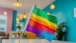 © CYBERUSS - A colorful pride flag stands proudly on a desk in a modern inclusive office space promoting LGBTQ representation and celebrating diversity