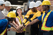 © amorn - Workers, Male, female workers. Group of male and female factory workers standing putting their hands together in industry factory. Factory workers stack of hands in factory. Unity and teamwork concept