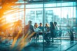 © ttonaorh - Blurred background of a business meeting in a modern office with people sitting at a table, a team working together having a discussion. View through a glass wall