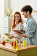 © LIGHTFIELD STUDIOS - Young couple sharing joy in the kitchen while preparing a delicious meal together at home