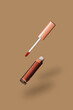 © VISTA by Westend61 - Floating brown lipstick tube and applicator on a beige background