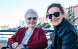 © almudena - Horizontal shot of a pretty, smiling older woman with her mature daughter looking at the camera showing the feminine beauty of two different generations.