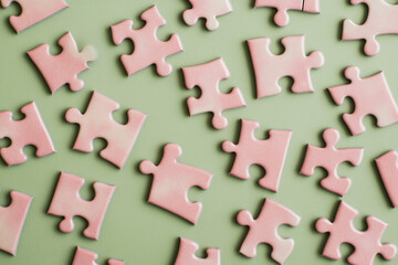 Poster - Pink puzzle pieces scattered on a green background, suggesting a concept of problem-solving, teamwork, or completion
