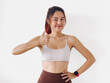© Suthida - Asian Thai woman wear white sport bras, happy confidence showing thumbs up, smiling while standing isolated over white background wall.