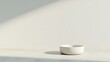 © Yulia - Minimalist bowl positioned on surface, soft shadows create seren