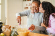 © DisobeyArt - African american mother and daughter having fun preparing sugar free cake at home - Family lifestyle, mom day and cooking healthy food concept - Focus on mum face