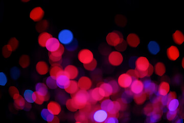 Aufkleber - Blurred red, purple and blue lights create a beautiful bokeh effect on a black backdrop, evoking a festive and dreamy atmosphere.