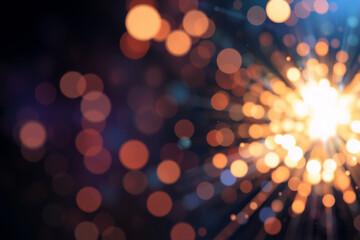 Fototapete - Warm bokeh lights in shades of orange and yellow radiate from a central bright spot, creating a vibrant, abstract and glowing effect against a dark backdrop.