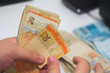 © Buonaventura - Businessman counting and exchanging money - Brazilian Real - Reais.