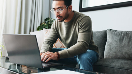 Fototapete - Glasses, reading and laptop with man on sofa for freelancer, business research and email. Communication, typing and online with person in living room at home for remote worker, networking and blog