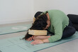 © SETO fotografias - Young woman doing yoga pose with a wooden block to stretch her vertebrae