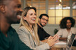 © Maskot - Smiling blond hair businesswoman in meeting with colleagues at office
