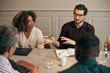 © Maskot - High angle view of young male creative professional explaining strategies to coworkers in office meeting room