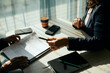 © Maskot - High angle view of female client giving pen to businesswoman holding contract at table in office