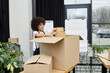 © LIGHTFIELD STUDIOS - Engaged professional packing moving boxes in a modern workspace during the day