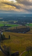 Wall Mural - aerial time lapse, motion view of a misty dramatic sunset over a countryside field village, golden s