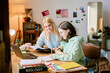 © AnnaStills - Two Caucasian females studying biology while sitting at desk in cozy bedroom with books and laptop on table, collaborating on homework assignments