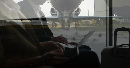 Poster - Using laptop and phone, business person working with airplane visible through window