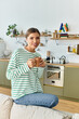 © LIGHTFIELD STUDIOS - Captivating moment of a young woman enjoying coffee in a cozy modern kitchen setting