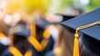 © Curioso.Photography - A graduate in a cap and gown with a yellow tassel, standing in a sea of fellow graduates, celebrating their academic achievement during a graduation ceremony.