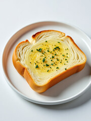 Poster - A Warm Slice Of Garlic Bread Sits Alone On A Clean White Plate.