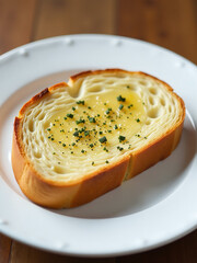 Poster - A Warm Slice Of Garlic Bread Sits Alone On A Clean White Plate.
