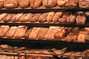 Poster - Breads on the shelf in the market or bakery.  bakery with many different types of bread on display. bread is arranged in rows and there are many different types of bread to choose from