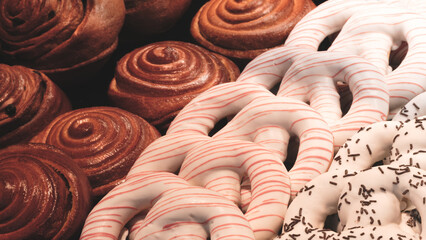 Poster - A row of pastries with a white stripe on them. The pastries are arranged in a row and include cinnamon rolls, doughnuts, and waffle cookies