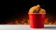 © TJ_Designs - Fried chicken in a pure red bucket with French fries on an empty white table, isolated on a black background with copy space