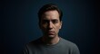 © Ilya - Thoughtful man reflecting against dark blue background