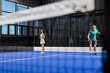 © Wavebreak Media - Playing padel tennis, energetic players enjoying match on indoor court