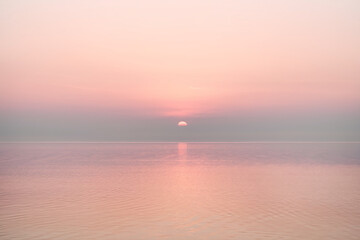 Aufkleber - Pink sunset over calm water, reflecting soft light, creating a serene and peaceful atmosphere, ideal for tranquility or meditation concepts