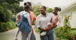© BuyOutFelix01/peopleimages.com - Outdoor, black family and parents with children for carrying, connection and bonding together by house. Hug, mom and dad with kids for conversation, walking and relationship on weekend in property