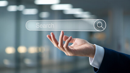 Poster - Hand holding transparent search bar with magnifying glass icon, set against a blurred office background, symbolizing internet search and information retrieval