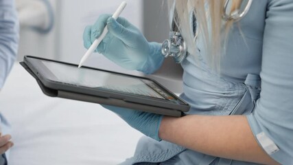 Poster - A gloved healthcare professional is using a tablet to review patient information during a consultation, showcasing the advancements of modern medical technology in todays healthcare