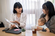 © Apichat - A woman is talking to a baby while holding a tablet