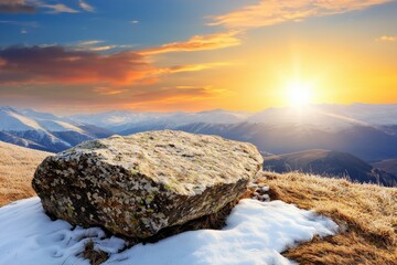 Wall Mural - Large rock sits on a snowy hillside, with the sun setting in the background