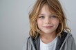 © CojanAI - Portrait of a young Caucasian girl with blond hair wearing gray jacket over white t shirt against plain white background