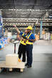 © Thanadon88 - Two men in safety vests are looking at a box on a pallet. They are discussing the box and its contents