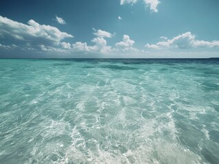 Poster - Crystal clear turquoise water and a serene blue sky with scattered white clouds create a tranquil and refreshing seascape. The scene evokes feelings of peace and natural beauty