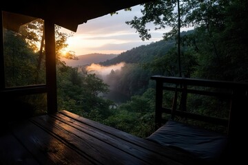 Fototapete - Sunrise view from wooden porch overlooking misty valley with lush green trees illuminated by golden sunlight and moody atmosphere