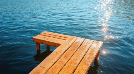 Poster - Wooden pier extending into a body of water reflecting sunlight. The pier is made of wooden planks with visible grain and texture. The water is a deep blue with sparkling highlights