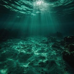 Poster - Underwater scene with sandy seabed and rocky formations illuminated by sunbeams in teal tones creating mysterious deep ocean feeling