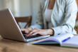 © Jelena Stanojkovic - Remote work, person and hands with laptop for typing, information and research for business article. Closeup, freelancer and journalist with digital for news website, story blog and keyboard at home.