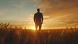 © Seno - Silhouette of a man standing in a golden wheat field at sunset, with vibrant clouds in the background