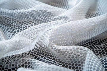Aufkleber - White fabric with honeycomb pattern forming beautiful folds and shadows on a black background