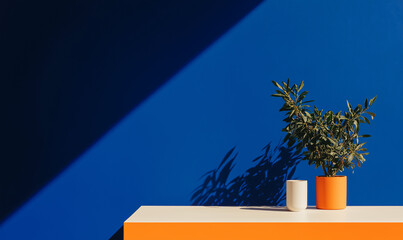 Poster - Harmonious Abstraction: An artistic composition featuring a modern aesthetic, juxtaposing a vivid blue wall with a contrasting orange surface, a vibrant potted plant and minimalist decor